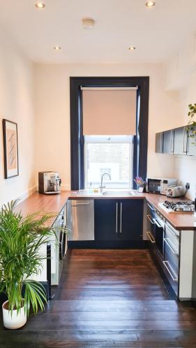 a large kitchen with a sink and a window at Unique and cozy apartment in central London in London