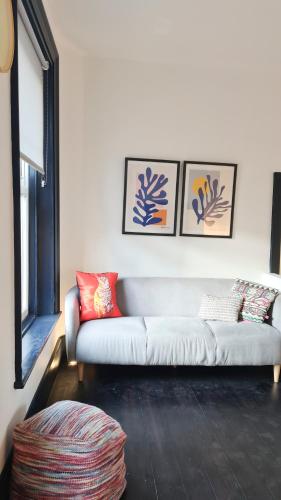 a living room with a white couch and three pictures on the wall at Unique and cozy apartment in central London in London