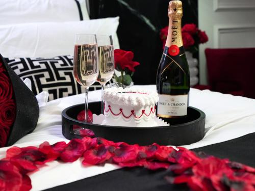 une bouteille de champagne, un gâteau et des verres à vin dans l'établissement La Suite Trocadéro - Jacuzzi privatif, à Paris