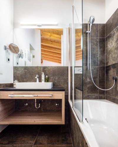 a bathroom with a tub and a sink and a shower at Alpine Hotel Gran Foda' in San Vigilio Di Marebbe