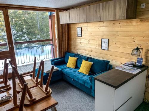 un salon avec un canapé bleu et une fenêtre dans l'établissement Petit Appart Cosy 4 pers en plein coeur d'Arc 1800, à Bourg-Saint-Maurice