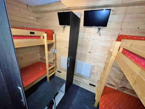 une chambre avec deux lits superposés et une télévision à écran plat dans l'établissement Petit Appart Cosy 4 pers en plein coeur d'Arc 1800, à Bourg-Saint-Maurice