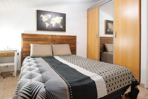 une chambre avec un grand lit avec une tête de lit en bois dans l'établissement Maison proche centre- ville et village Vendée Globe Les Sables - 6 personnes, à Les Sables-dʼOlonne