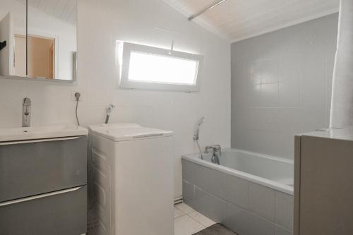 une salle de bain blanche avec un lavabo et une baignoire dans l'établissement Maison proche centre- ville et village Vendée Globe Les Sables - 6 personnes, à Les Sables-dʼOlonne