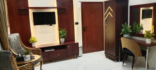 a living room with a tv and a table and chairs at Diplomat Fort Boutique Hotel in Karachi