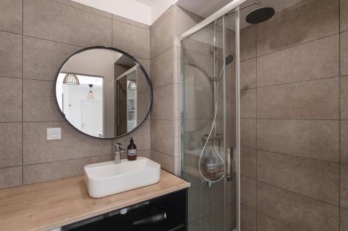 une salle de bain avec un lavabo et un miroir dans l'établissement L'Atelier - Appt 2 chambres avec parking, à Rennes
