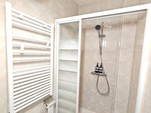 une douche avec pommeau de douche dans une salle de bain dans l'établissement 3 Pièces près de Paris - Métro 4, à Saint-Ouen