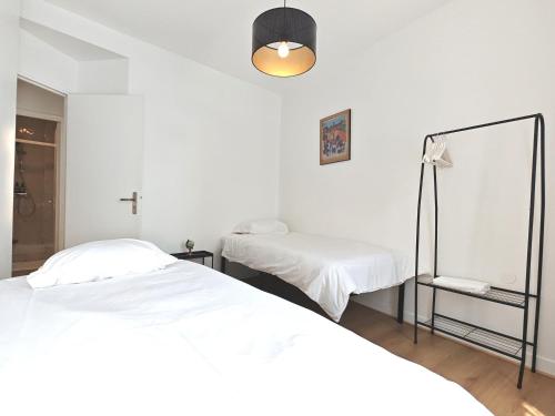 une chambre avec deux lits et un miroir dans l'établissement 3 Pièces près de Paris - Métro 4, à Saint-Ouen