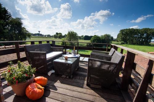 a deck with a table and chairs and pumpkins at Vakantiehuis De Stokerij in Oudenburg