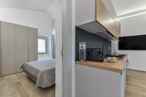 a room with a bed and a kitchen with a sink at Casina Napoleonica in Lacona