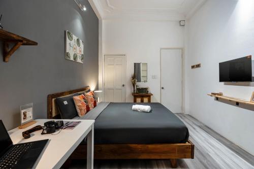 a bedroom with a bed and a desk with a laptop at HoLo Fairy House Saigon - Serviced Homestay in Ho Chi Minh City