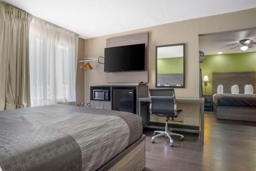 a hotel room with a bed and a desk with a computer at Rodeway Inn Tuscaloosa near University in Tuscaloosa