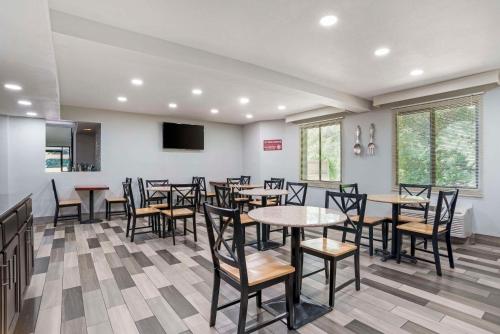 a dining room with tables and chairs and a flat screen tv at Rodeway Inn Tuscaloosa near University in Tuscaloosa