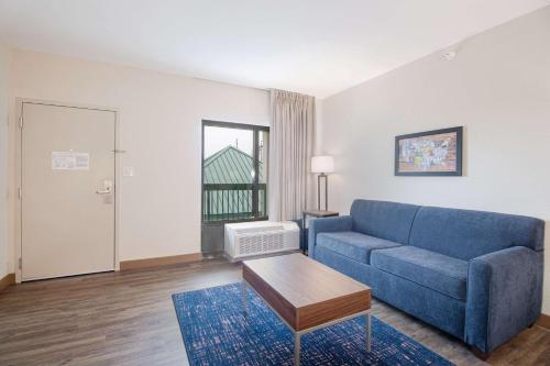 a living room with a blue couch and a table at Econo Lodge Inn & Suites Foley-North Gulf Shores in Foley
