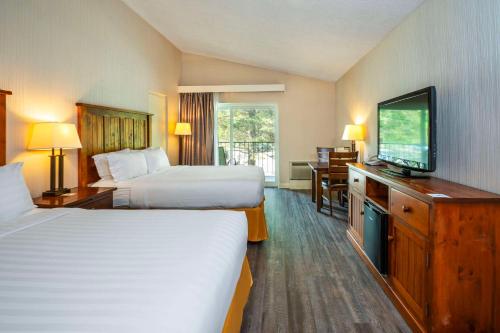 a hotel room with two beds and a flat screen tv at Hidden Valley Resort, an Ascend Collection Resort in Huntsville
