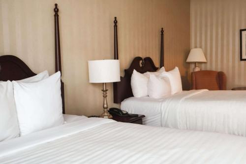a hotel room with two beds with white sheets at Quality Inn & Suites Downtown in Charlottetown