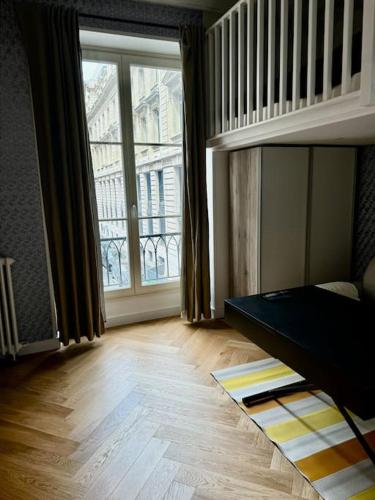 Cette chambre comprend un lit et une grande fenêtre. dans l'établissement Appartement au cœur de Paris, à Paris