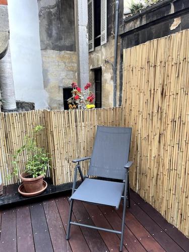 a chair sitting on a deck with a fence at Grand appartement central aéré avec terrasse in Bordeaux