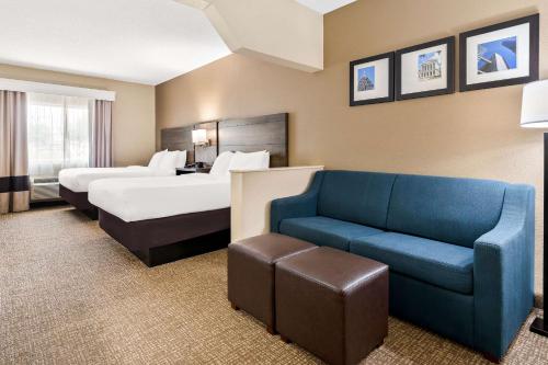 a hotel room with two beds and a couch at Comfort Suites near Robins Air Force Base in Warner Robins