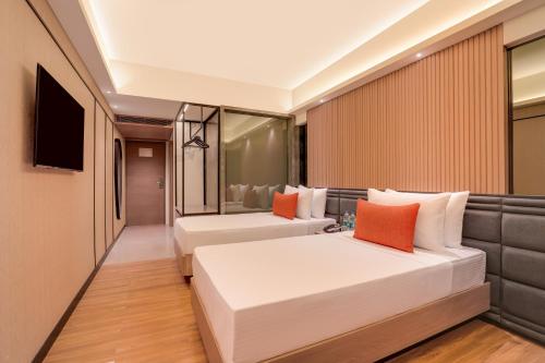 a hotel room with two beds and a television at Lemon Tree Premier, Malad, Mumbai in Mumbai