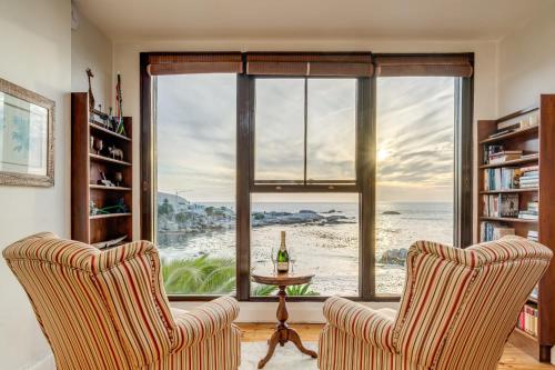 a living room with two chairs and a large window at Camps Bay Terrace Lodge in Cape Town