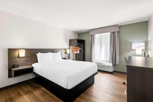 a hotel room with a large bed and a window at Quality Inn Merrimack - Nashua in Merrimack