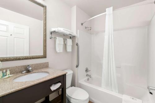 a white bathroom with a sink and a shower at Quality Inn Merrimack - Nashua in Merrimack