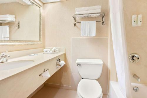 un bagno con un water, un lavandino e uno specchio di Quality Inn Edison-New Brunswick a Edison