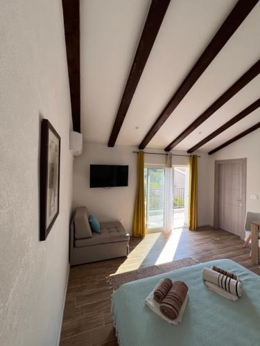 Apartmani Mareta في بتروفاتس نا مورو: غرفة نوم بها سرير وأريكة في الغرفة