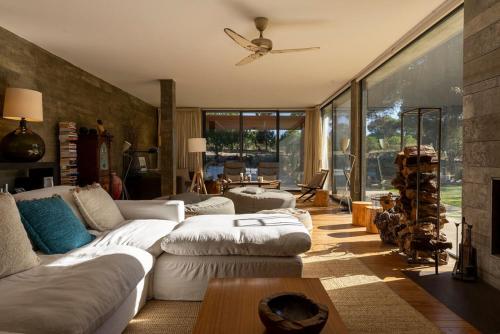 a living room with white couches and a ceiling fan at The Pine Tree Comporta Villa in Carvalhal