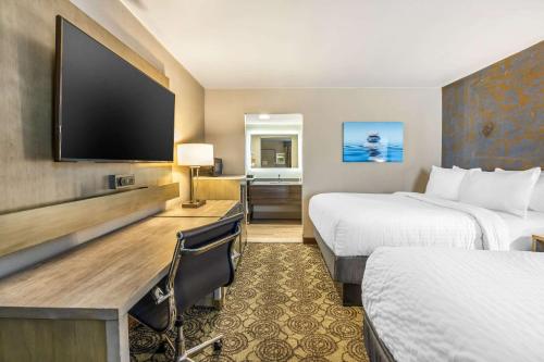 a hotel room with two beds and a flat screen tv at Clarion Inn Murfreesboro Old Fort Pkwy in Murfreesboro