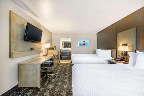 a hotel room with two beds and a flat screen tv at Clarion Inn Murfreesboro Old Fort Pkwy in Murfreesboro