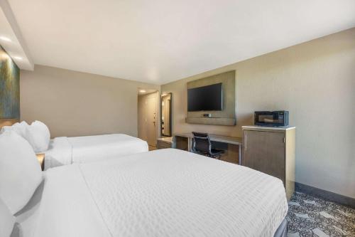 a hotel room with two beds and a flat screen tv at Clarion Inn Murfreesboro Old Fort Pkwy in Murfreesboro