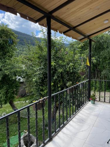 a balcony with a view of a tree at Mamuka Chartolani Guesthouse in Mestia