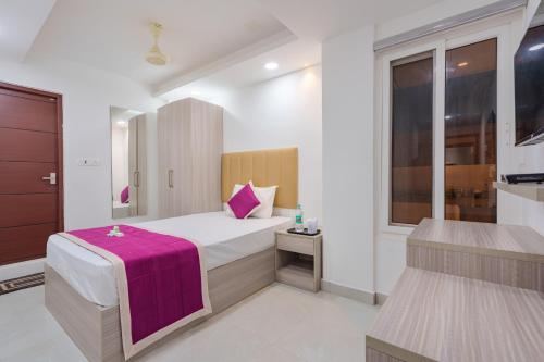 a bedroom with a bed with a purple blanket at GRACE REGENCY in Ernakulam