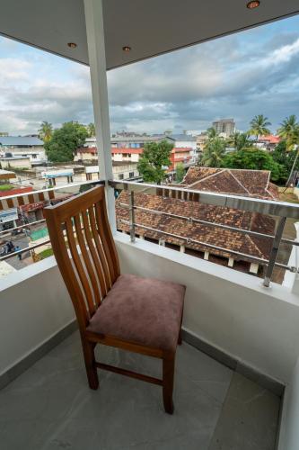 a chair on a balcony with a view of a city at GRACE REGENCY in Ernakulam