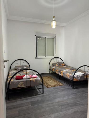a room with two beds in a room at Appartement à louer Complexe City Center in Oued Laou