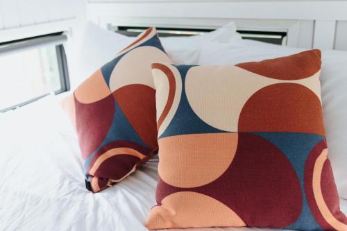 a bed with two pillows on top of it at Sweet Hart 1 by Tiny Away in Tamahere