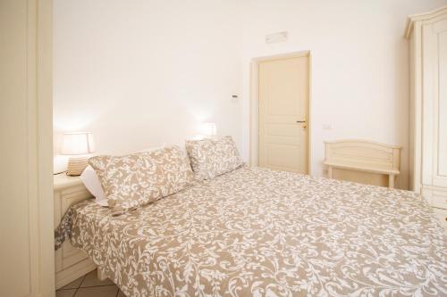 a white bedroom with a bed with a blanket at LA CASA DEL SOLE - Beachfront B&B - Anzio in Anzio
