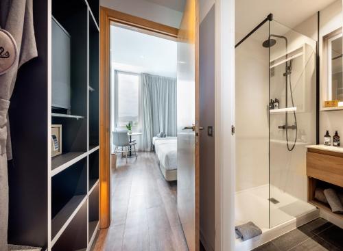a bathroom with a shower and a bedroom at INNSiDE by Meliá Barcelona Aeropuerto in El Prat de Llobregat