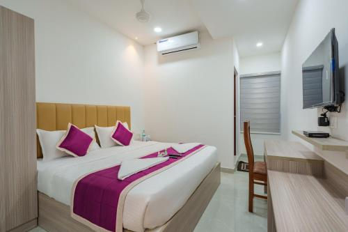 a bedroom with a large bed with purple pillows at GRACE REGENCY in Ernakulam
