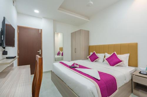 a bedroom with a large bed with purple pillows at GRACE REGENCY in Ernakulam
