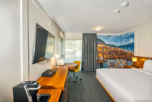 Una cama o camas en una habitación de Clarion Pointe La Malbaie
