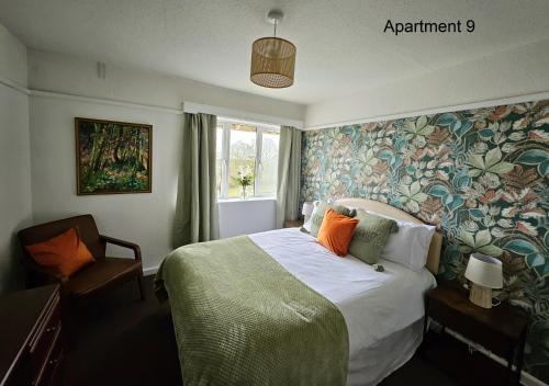 a bedroom with a bed with a floral wallpaper at Beach Court Holiday Apartments in Skegness