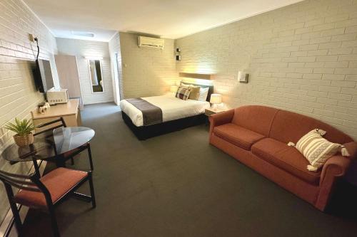a bedroom with a bed and a couch in a room at Econo Lodge Gateway Tamworth in Tamworth