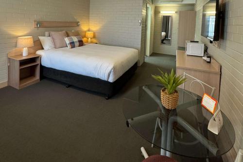 a bedroom with a bed and a glass table at Econo Lodge Gateway Tamworth in Tamworth
