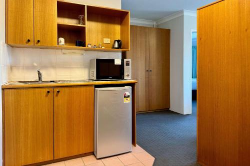 a kitchen with a refrigerator and a microwave at Econo Lodge Gateway Tamworth in Tamworth