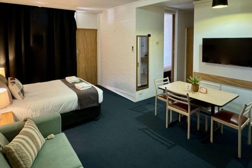 a hotel room with a bed and a table at Econo Lodge Gateway Tamworth in Tamworth