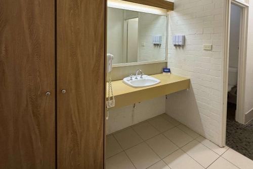 a bathroom with a sink and a mirror at Econo Lodge Gateway Tamworth in Tamworth