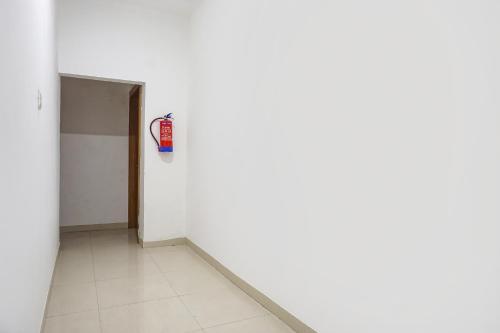 an empty room with a fire extinguisher on the wall at FabHotel The White House Inn - EON IT Park in Pune